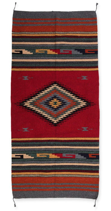 Handwoven southwest style acrylic rug in size 32" x 64". Rust and earth tones.