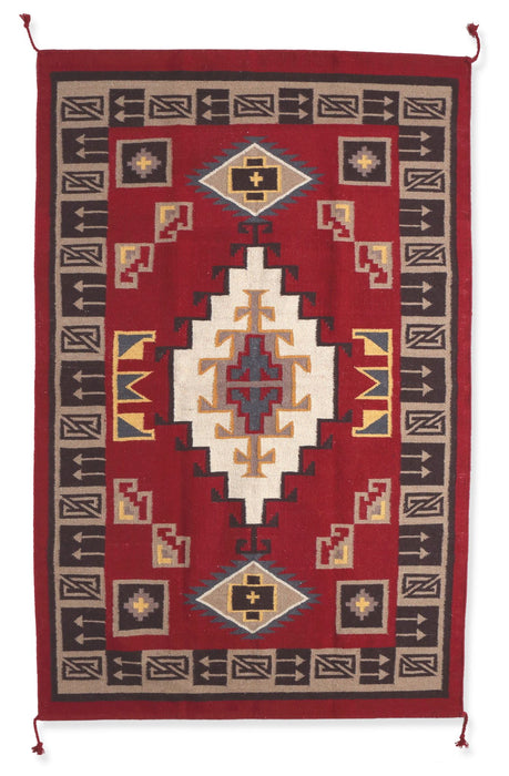 An intricately woven floor rug in a southwest-style design.  Colors include browns and rust.